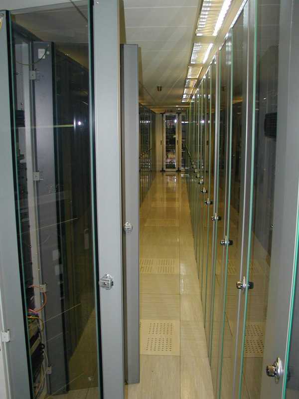 Inside the hosting facility, the walkway between rows of cabinets (glass fronted wardrobe-like boxes with shelving to insert thin servers.  The thinner the server, the more you could pack in a rack.