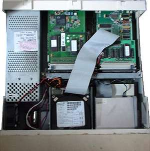 A310 with the top removed, revealing (top) a power supply; two upgrade cards; (bottom) a hard drive; and a floppy drive.